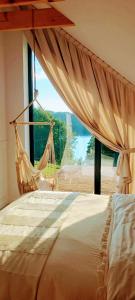 a bed with a hammock in a room with a window at Stodoła Rzym - domek, jacuzzi, sauna, jezioro, las in Kożyczkowo +54 photos