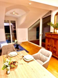a wooden table with two chairs and a dining room at Apartments C'EST LA SEA - Whirlpool-Suite oder Dachterrassen-Suite - Pets welcome in Neusiedl am See