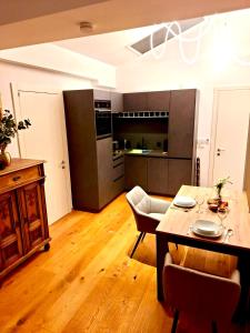 a living room with a table and a kitchen at Apartments C'EST LA SEA - Whirlpool-Suite oder Dachterrassen-Suite - Pets welcome in Neusiedl am See +58 photos