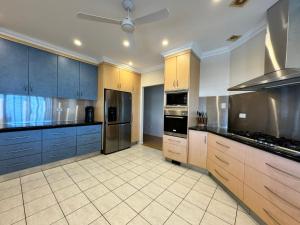 a large kitchen with wooden cabinets and stainless steel appliances at Townsville Apartments on The Strand - Penthouse in Townsville