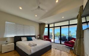 a bedroom with a bed and a large window at Townsville Apartments on The Strand - Penthouse in Townsville +54 photos