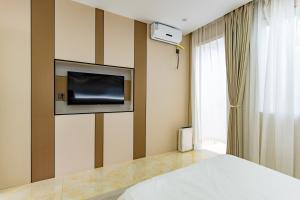 una camera da letto con un letto e una TV a parete di 在盐官民宿 a Hsü-chia-ch'iao