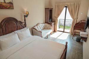 a bedroom with a bed and a chair and a window at The Farmhouse in Ipoh