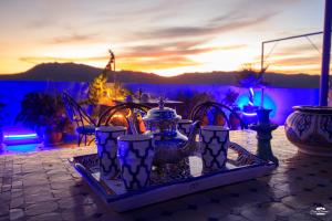 a tray filled with vases on a table with a sunset at Casa Voyager 'secret garden terrace' in Chefchaouen