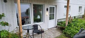 a patio with a table and chairs in front of a house at Small cosy and fully equipped apartment with the possibility to rent a car in Tromsø +2 photos