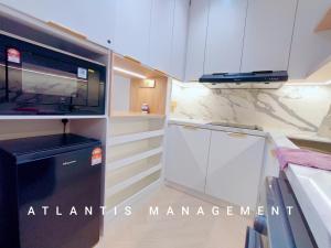 une cuisine avec des armoires blanches et un appareil noir dans l'établissement Arte Mont Kiara, Private Elegant Suite manage by Atlantis Management, à Kuala Lumpur