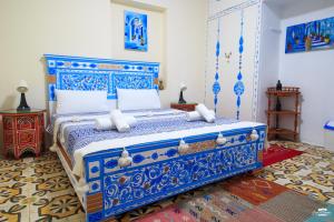a bedroom with a blue and white bed in a room at Casa Voyager 'secret garden terrace' in Chefchaouen