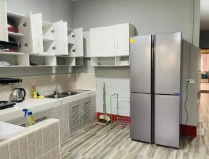 a kitchen with a refrigerator and white cabinets at Madam nay house service in Ban Prong Phra Bat Nok (1)