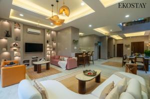 sala de estar con muebles y TV de pantalla plana. en EKOSTAY - Casa Enzo, en Lonavala