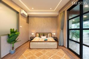 Un dormitorio con una cama y una ventana grande. en EKOSTAY - Casa Enzo, en Lonavala