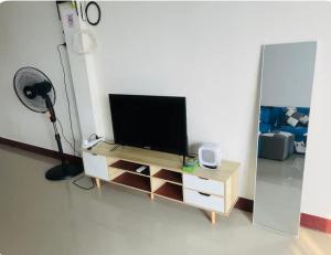 a living room with a television on a wooden entertainment center at Madam nay house service in Ban Prong Phra Bat Nok (1)