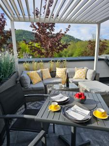 a patio with a table and a couch at Apartment Blicksüd in Unterburg am Klopeiner See