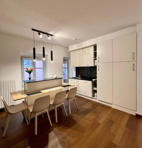 Una cocina con mesa de comedor y sillas. en Dimora Rosé, en Alba