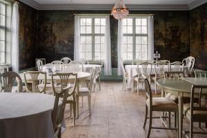 una sala da pranzo con tavoli e sedie e un lampadario di Skrivergaarden - ei historisk perle a Løkja
