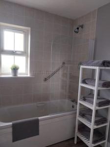 a bathroom with a white bath tub and a shelf at Beautiful home kenmare in Kenmare
