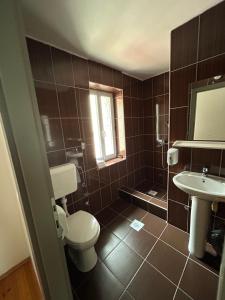 a bathroom with a toilet and a sink at Hotel Andrićgrad in Višegrad +84 photos