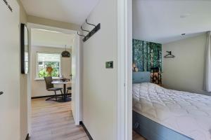 a bedroom with a large bed and a table at Comfortabel 2- persoons vakantiehuis nabij bos in Drenthe in Schoonoord