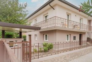 ein weißes Gebäude mit einem Balkon und einem Zaun in der Unterkunft Novalesi Vintage interno 2 in Noale