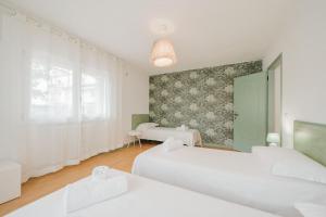 ein Schlafzimmer mit zwei weißen Betten und einem Fenster in der Unterkunft Novalesi Vintage interno 2 in Noale