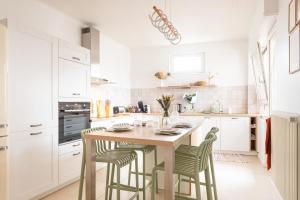 a white kitchen with a wooden table and chairs at Ulsibé in Schiltigheim