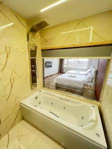 a bathroom with a tub and a bed in a mirror at Pyramids Enigma Grand Lodge in Cairo