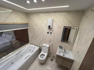 a bathroom with a tub and a toilet and a sink at Pyramids Enigma Grand Lodge in Cairo