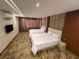a hotel room with two beds and a television at Pyramids Enigma Grand Lodge in Cairo