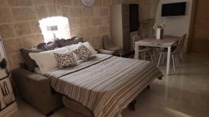 a bedroom with a bed with a couch and a table at Rossè B&B Holiday House in Trani