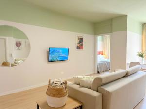 a white living room with a couch and a bed at Cozy Nest Golem in Golem