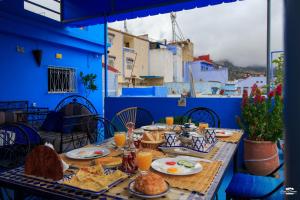 a table with food on top of a blue building at Casa Voyager 'secret garden terrace' in Chefchaouen