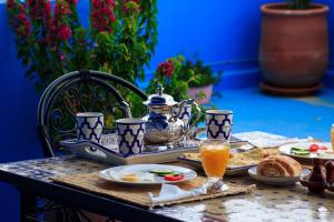 a table with plates of food and a teapot at Casa Voyager 'secret garden terrace' in Chefchaouen +50 photos