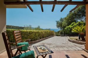 a patio with chairs and a table with a view at ISA-Ecovillage with swimming-pool in Teulada surrounded by greenery just 400 meters from the sea in Teulada