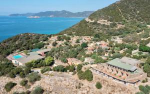 an aerial view of a house on a hill next to the water at ISA-Ecovillage with swimming-pool in Teulada surrounded by greenery just 400 meters from the sea in Teulada +14 photos
