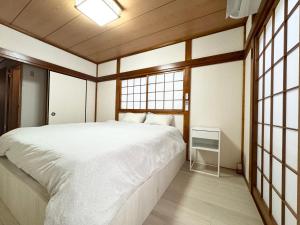东京Family House 蕾 池袋徒步圈全新装修日式户建民宿的带一张白色大床和窗户的卧室 更多37张照片