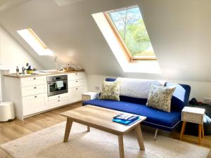 un soggiorno con un divano blu e una cucina di The Loft at Craiglea a Pitlochry