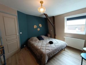 a bedroom with a bed and a blue wall at Maison de vacances près de la digue et plage in Dunkerque