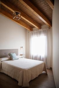 a bedroom with a large bed with a window at El gallinero de la abuela Claudia in Aldea de Trujillo