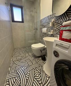a bathroom with a black and white patterned floor at Maslina- 3 bedroom apartment in Kotor