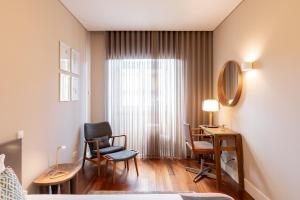 a room with a desk and chairs and a window at VIVA Aliados Spacious & Bright Flat in Porto