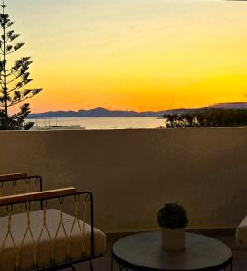 a view of a sunset from a balcony with a table at Aphrodite Boutique Hotel in Aliki