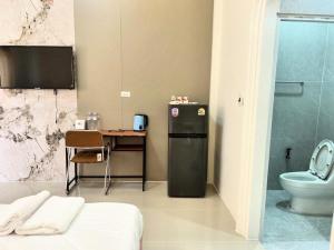 a bathroom with a small table and a refrigerator at Katthaleeya Resort คัทลียา รีสอร์ท in Kantharalak