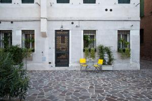 two chairs and a table in front of a building at Lemon House in Venice +37 photos