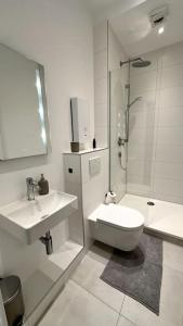 a bathroom with a toilet and a sink and a shower at City Oase - Apartment in Top Lage in Braunschweig +3 photos