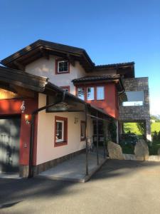 a red and white house with a garage at Ferienhaus Philipp Rofner in Leogang
