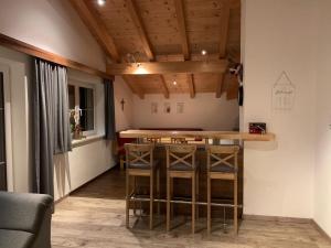 a kitchen with a bar in a room with wooden ceilings at Ferienhaus Philipp Rofner in Leogang