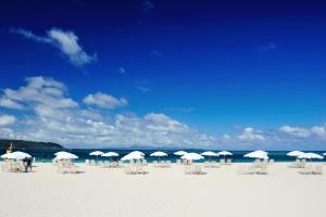 a group of chairs and umbrellas on a beach at Okuma Private Beach & Resort in Kunigami