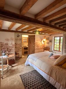 a bedroom with a large bed and a desk at Le Domaine de Blanvatel in Sainte-Marguerite-de-Viette