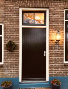 a black garage door on a brick house at Studio in farmhouse Close to Giethoorn in Kallenkote