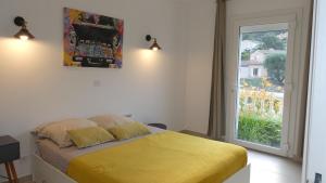 a bedroom with a yellow bed and a window at Bas de villa indépendant prestations haut de gamme in Vallauris +12 photos