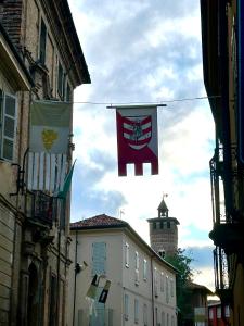 a group of flags hanging from buildings on a street at CENTRO STORICO - San Secondo Luxury Apartment in Asti +17 photos
